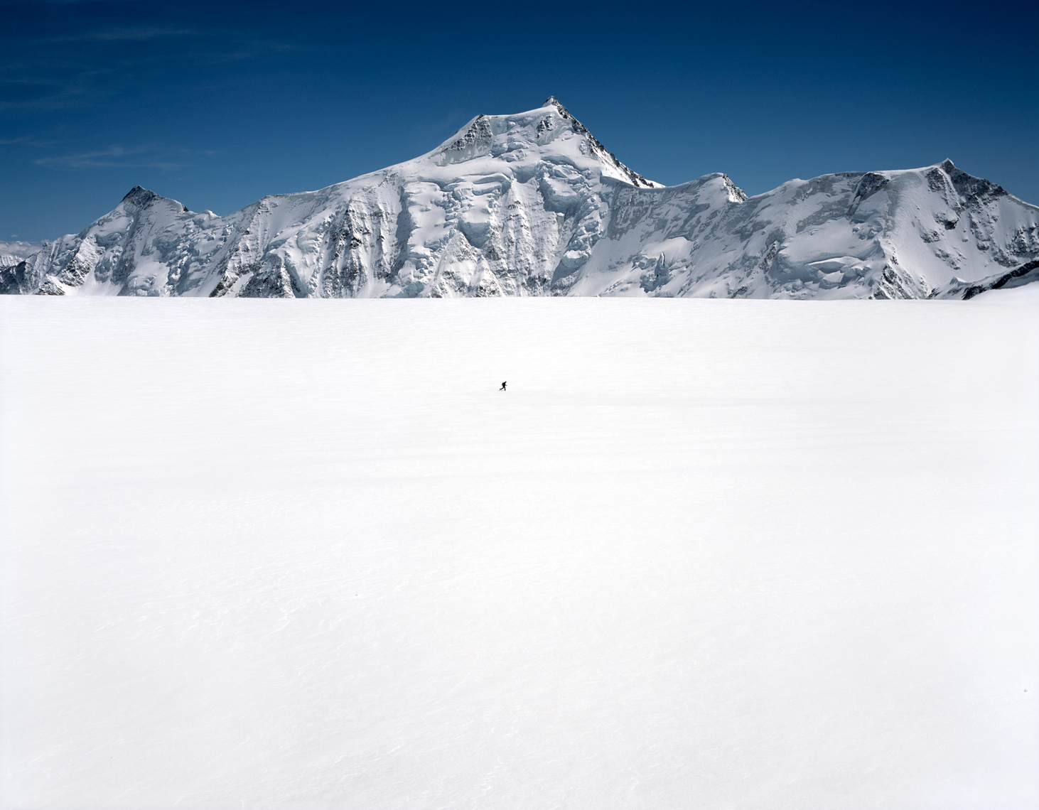 Jon Wyatt Photography - Solo ski tourer in front of Finsteraarhorn mountain, Bernese Oberland,  Switzerland